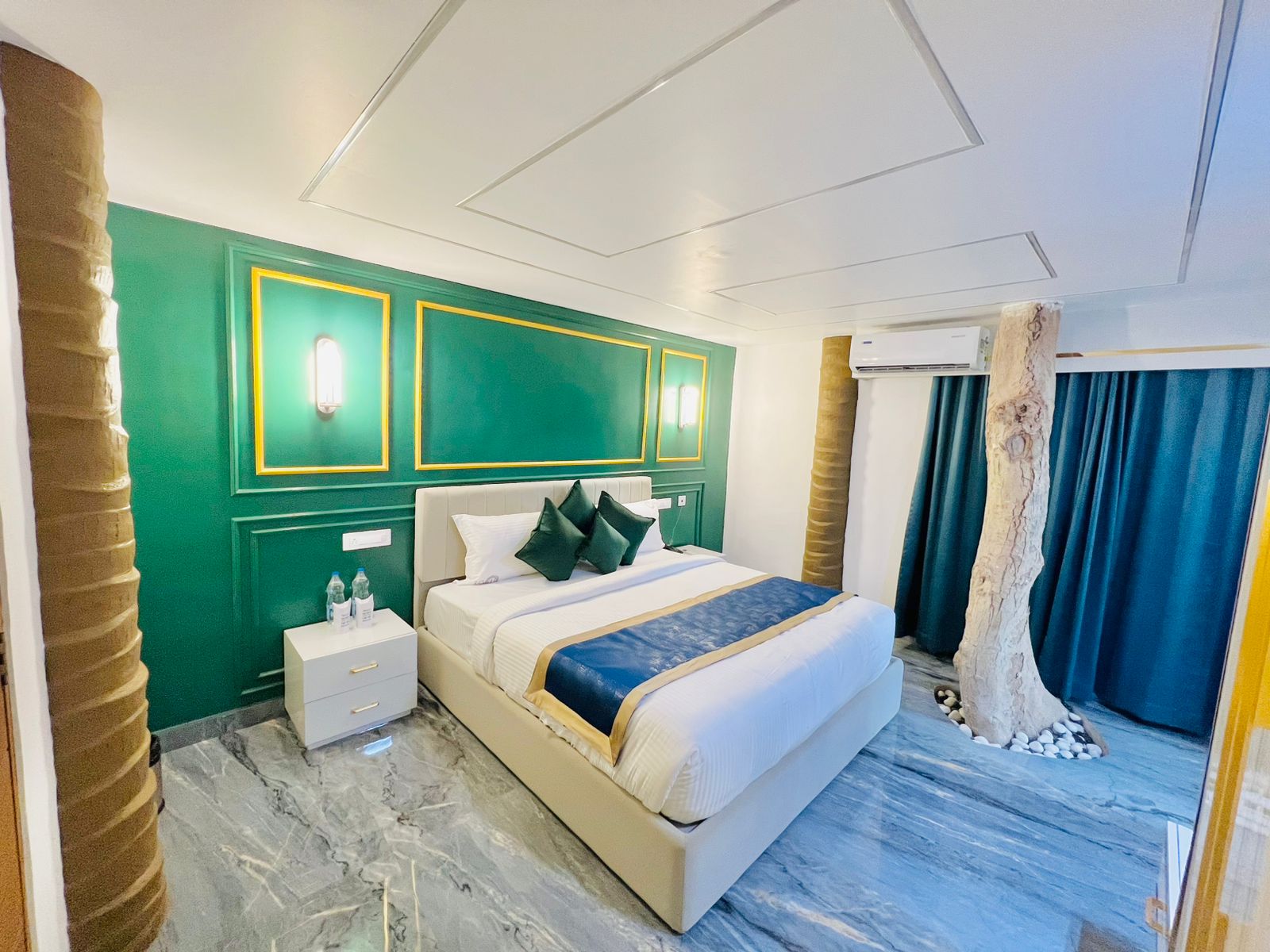 Luxury Villa bedroom with emerald accent wall and tree-trunk feature